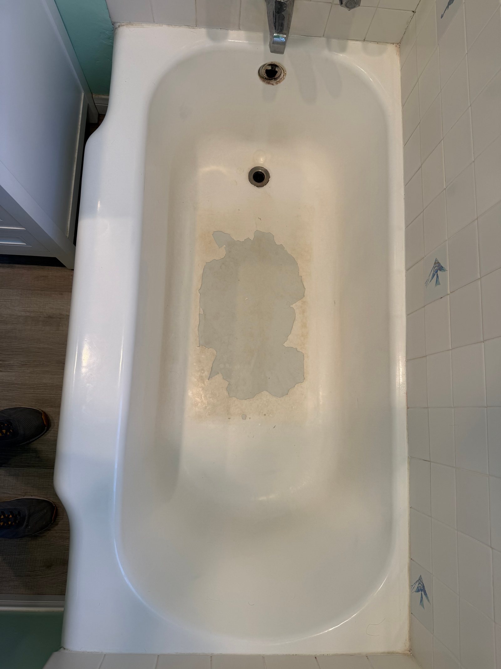 Peeling bathtub coating viewed from above before refinishing